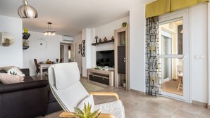A modern living room with a sofa, a recliner, a TV, and a dining area. - Spectacular sea views parking and pool  REF006 (Benalmádena)