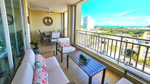 Een balkon met een bank, stoelen, een tafel en uitzicht op de stadsgezicht.