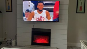 Un televisor montado en la pared sobre una chimenea.