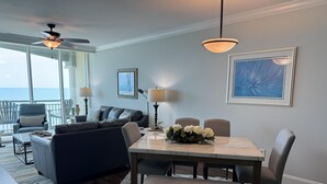 A modern living room with a dining area, a ceiling fan, and a view of the ocean. - MVG 1512 Oceanfront, Penthouse (North Myrtle Beach)