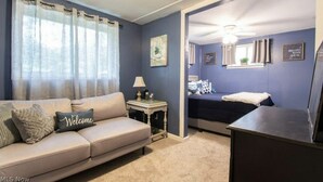Une chambre à coucher avec un lit, une table de chevet, une lampe et une commode.