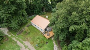 Une maison à deux étages avec une cour clôturée et une terrasse.