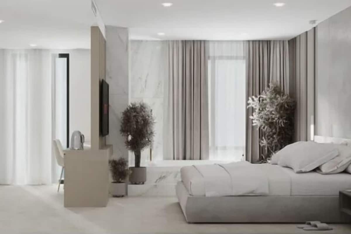 Un dormitorio moderno con cama, mesita de noche y un ventanal con cortinas.