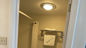 Un baño pequeño y funcional con inodoro, cortina de ducha y barra para toallas.