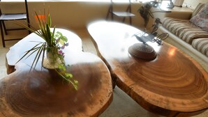 Une table basse en bois, ornée d’une plante, d’une sculpture représentant un vélo et d’un set de table en fibres tressées.