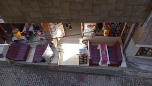 Un restaurant dont la façade est recouverte de carreaux, avec une fenêtre aux cadres en bois et une enseigne suspendue qui fait la publicité de la cuisine péruvienne.