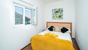 A bedroom with a bed, a window with a view, and a painting on the wall. - Apartments Sandito - Two Bedroom Apartment with Terrace and Sea View (Mlini)