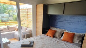 Une chambre à coucher moderne avec un grand lit, deux oreillers et une tête de lit.