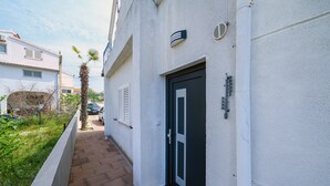 Un sentiero stretto che porta a un edificio con una porta nera e una piccola finestra.