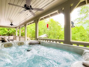 A hot tub with a ceiling fan, surrounded by a wooden deck with chairs and a table. - Smoky Mountain Cabin w/ Hot Tub & View | Private - Cherokee & Bryson City (Whittier)