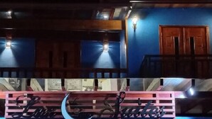 A building with a blue exterior and a wooden door. - Pousada Luz da Lua (Búzios)
