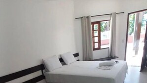 A room with two single beds, a window with curtains, and a door leading outside. - Hotel Porto Brasília (Porto Seguro)