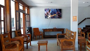 A room with wooden furniture, a painting on the wall, and a staircase. - Hotel Porto Brasília (Porto Seguro)