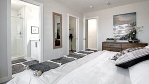 Un dormitorio con una cama grande, un aparador, un espejo y un cuadro en la pared.
