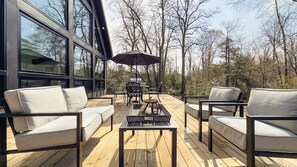 Una terraza con mobiliario exterior, una chimenea y un paraguas grande.