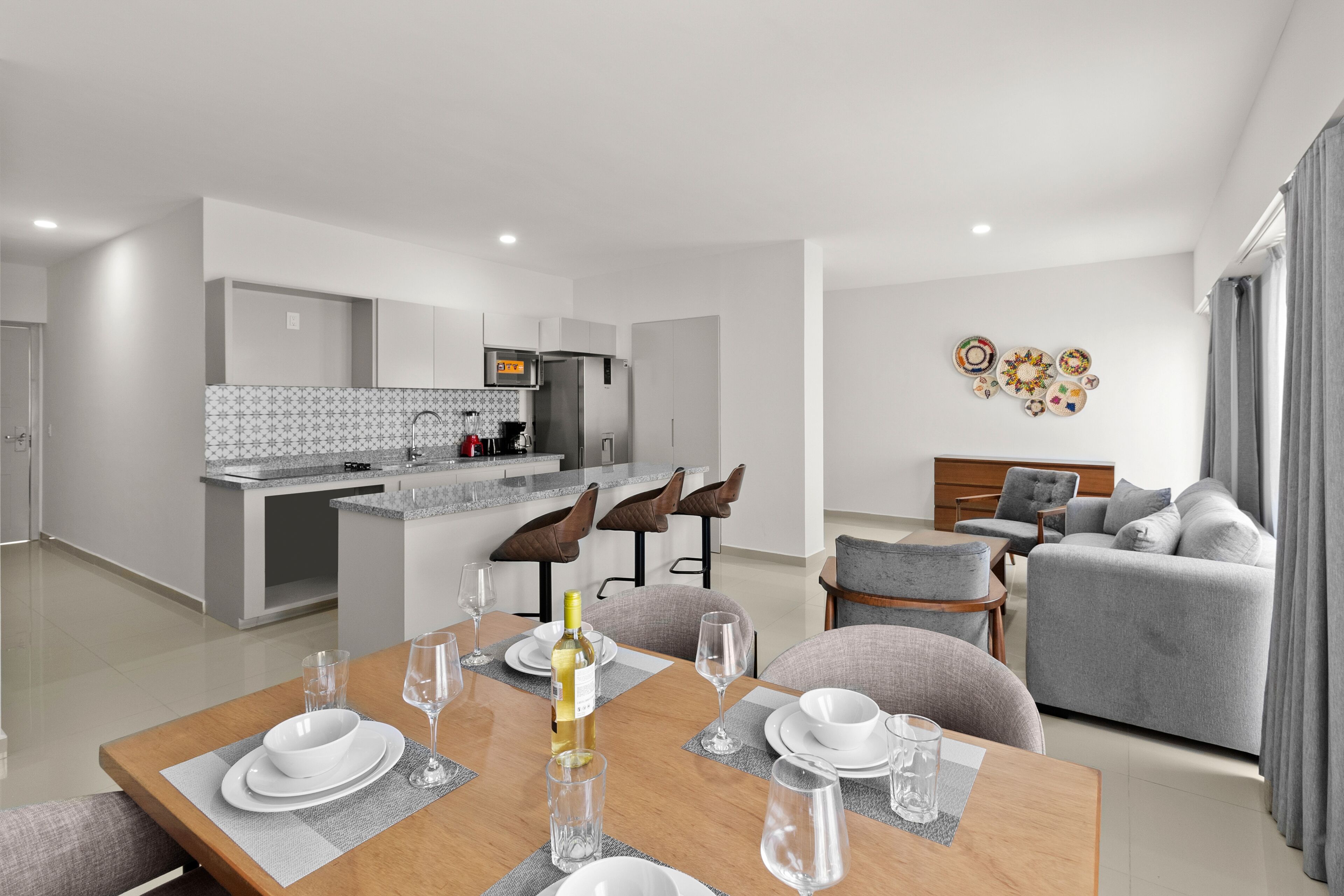 A modern apartment with a dining area, kitchen, and living room.
