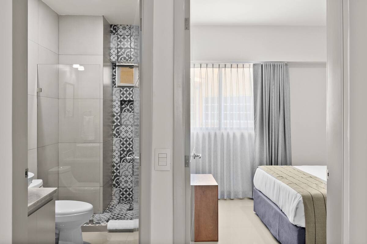 A modern bathroom with a shower, toilet, and sink.