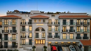A multi-story hotel with a central entrance, balconies, and a tiled roof. - Casa Barros Vacation Condos (Mazatlán)
