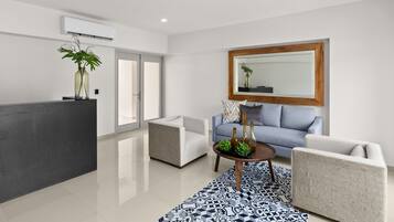 A modern living room with a grey sofa, a coffee table, and a patterned rug.