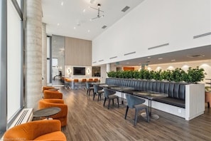 A modern interior with a bar area, seating, and a large window. - Stylish Open Concept Condo w/Gym (Kitchener)
