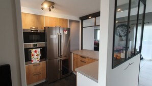 Una cocina moderna con electrodomésticos de acero inoxidable, armarios de madera y un amplio ventanal.
