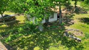 A small cabin with a porch, surrounded by trees and a grassy yard. - Lake View Cabin on Lake Norfork (Mountain Home)