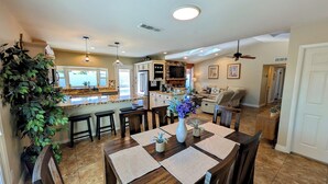 A spacious kitchen with a dining area, a stone fireplace, and a ceiling fan. - Exceptional! Remodeled 3Bd / 2Ba with GIANT Private Pool and Covered Patio (Phoenix)