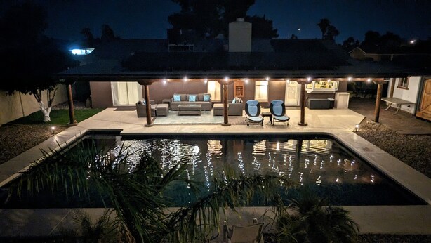 A swimming pool with a patio area featuring outdoor furniture and ambient lighting. - Exceptional! Remodeled 3Bd / 2Ba with GIANT Private Pool and Covered Patio (Phoenix)
