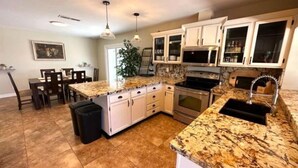 A kitchen with white cabinets, a granite countertop, and stainless steel appliances. - Exceptional! Remodeled 3Bd / 2Ba with GIANT Private Pool and Covered Patio (Phoenix)