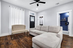 Relax in this stylish living room with a large sofa and elegant armchair.