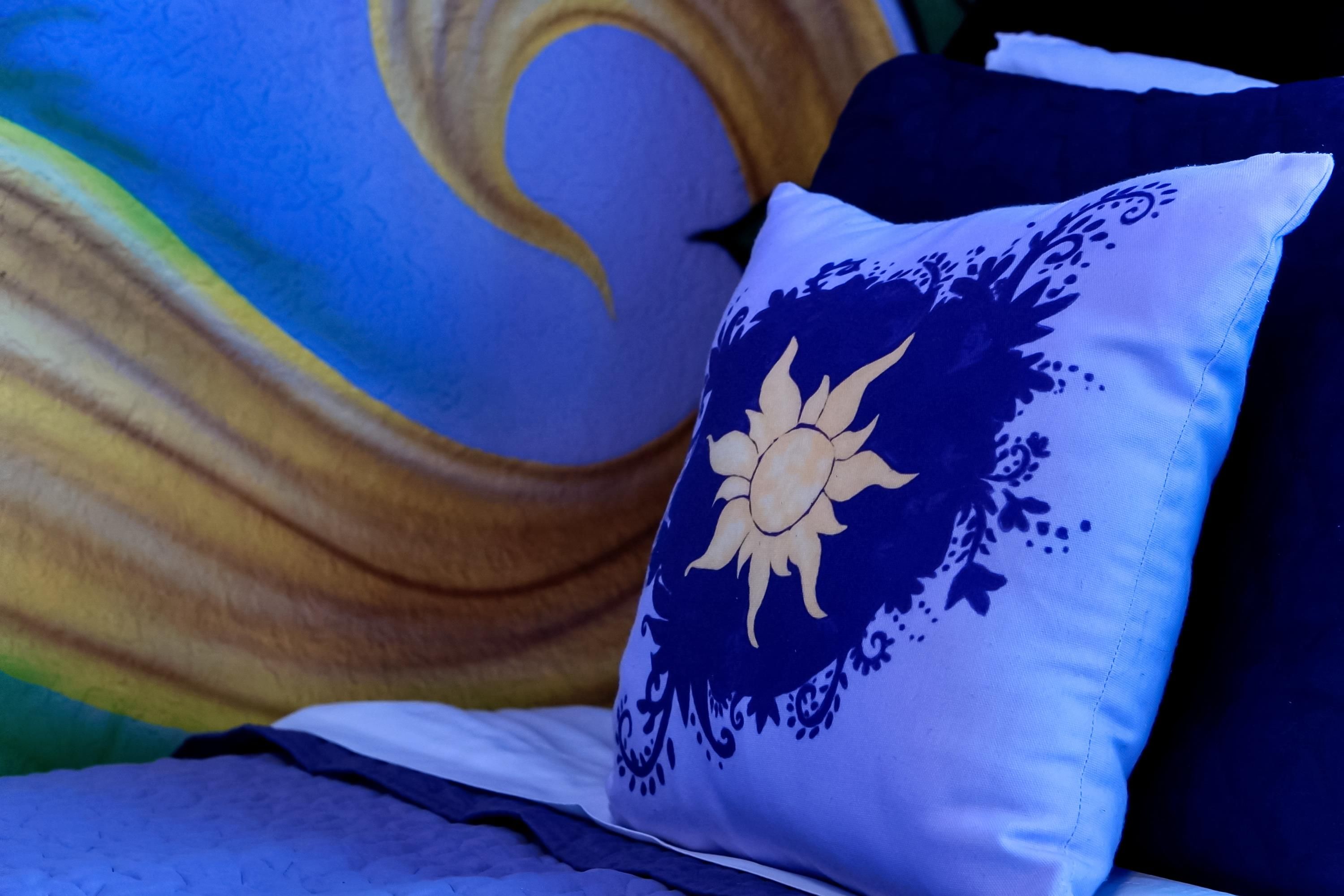 Ein Bett mit einem Kopfkissen mit Sonnendesign.