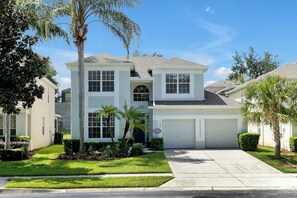 A two-story house with a garage, a driveway, and a well-maintained lawn. - Windsor Hills Villa, Pool/Spa free heat, Disney (Kissimmee)