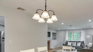 A modern living space with a dining area, a sofa, and a kitchen in the background. - Beautiful House near Beach and Castle Hill (Middletown)