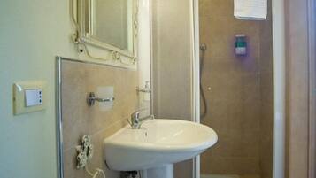 Un baño con lavamanos, inodoro y ducha.