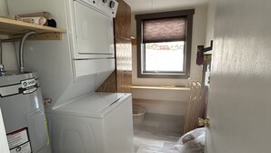A compact laundry room with a washer, dryer, and stacked washer-dryer unit.