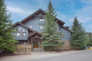 A multi-story lodge with a stone facade, large windows, and a prominent entrance.