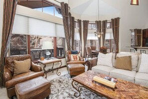 A spacious living room with leather furniture, a coffee table, and a sofa.