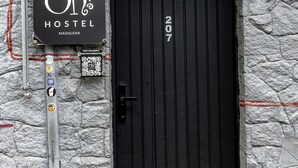 Un cartel de hostal con el nombre 'Oh! Hostel' y la dirección '207'.