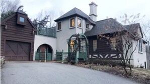 Et toetagers hus med garage, sort jerngitter og skorsten.