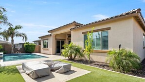A residential property with a swimming pool, outdoor seating, and a well-maintained lawn. - Luxury Home in Litchfield Park w/Free Pool Heating (Litchfield Park)