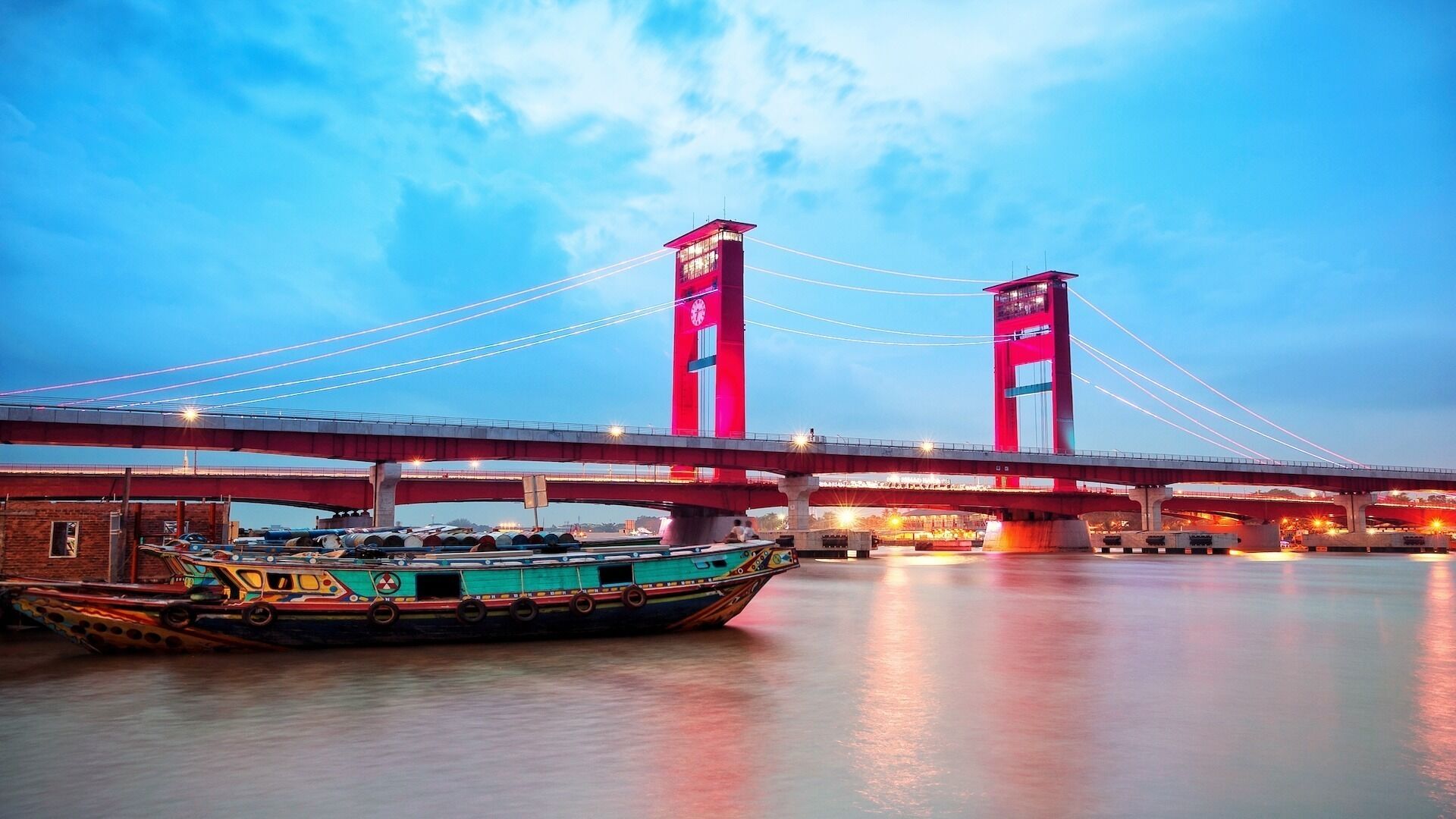 A bridge with two towers and a boat docked in the foreground.