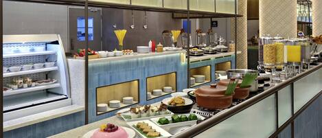 A buffet with various food items and a refrigerator.