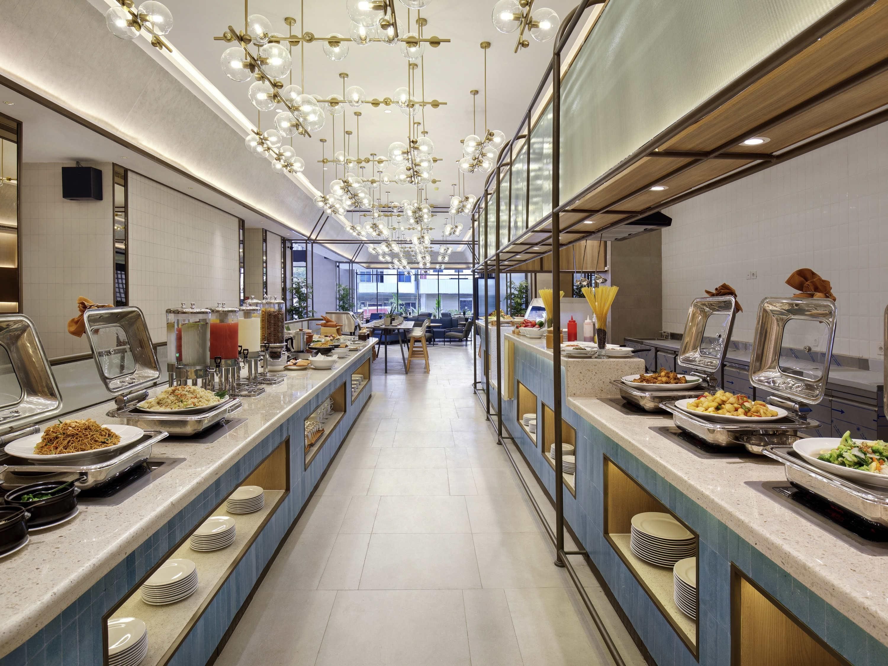 A buffet setup with multiple serving stations, a long counter, and a modern ceiling design.