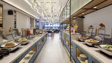 A buffet setup with multiple serving stations, a long counter, and a modern ceiling design.
