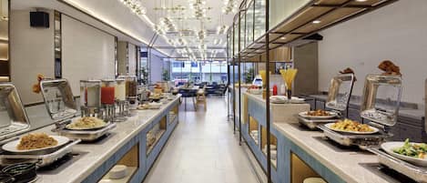 A buffet setup with multiple serving stations, a long counter, and a modern ceiling design.