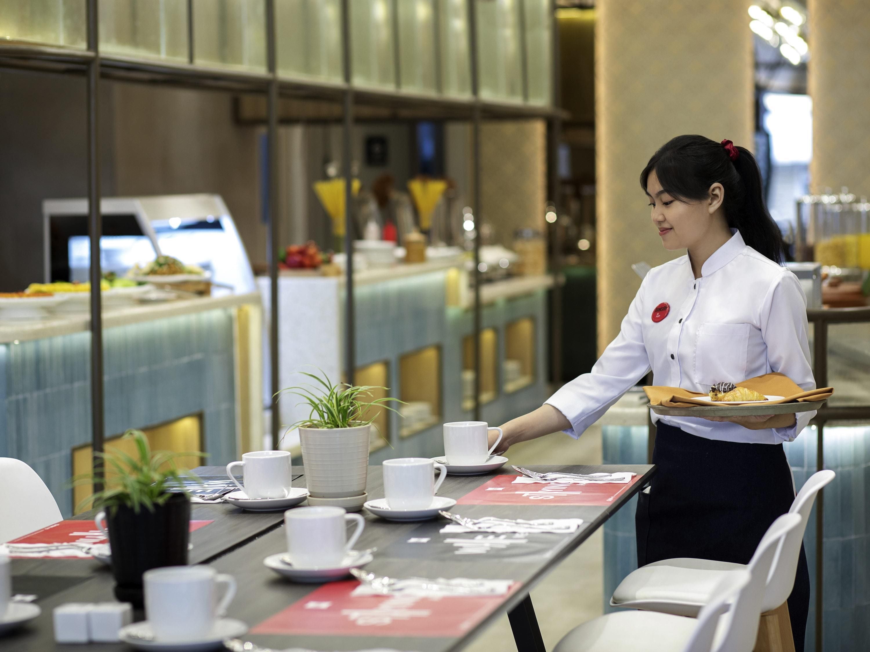 Ein Hotelrestaurant, in dem ein Kellner Essen serviert.