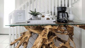 A modern kitchen with a glass coffee table, white cabinetry, and a wooden coffee table with a unique design.