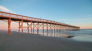 Une jetée qui s’avance dans l’eau, avec un ciel dégagé au-dessus.