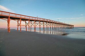 Ein Steg, der sich ins Wasser erstreckt, mit blauem Himmel darüber.