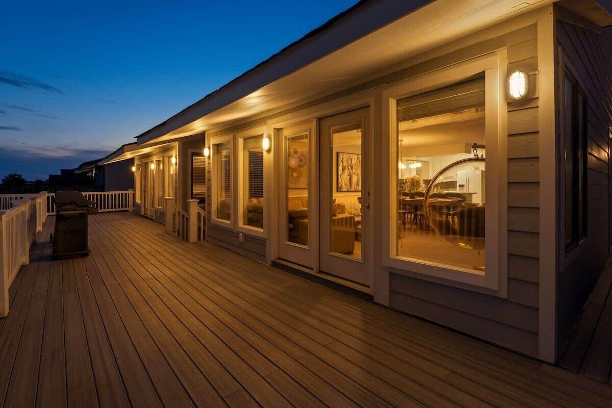 A wooden deck with a covered outdoor area, including a seating area with tables and chairs.